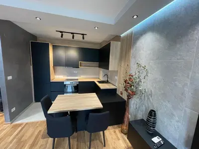 a kitchen with a table and some blue cabinets at Montenegro Platinum Suite - New City in Podgorica