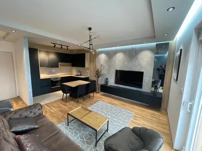 a living room with a couch and a table at Montenegro Platinum Suite - New City in Podgorica