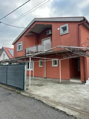 a red brick building with a gate in front of it at Pause - cozy Podgorica apartment in Podgorica