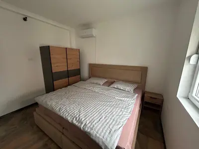 a small bedroom with a bed and a dresser at Pause - cozy Podgorica apartment in Podgorica