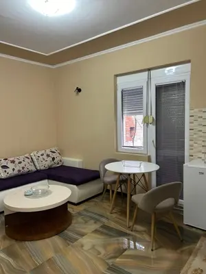 a living room with a couch and a table at Pause - cozy Podgorica apartment in Podgorica