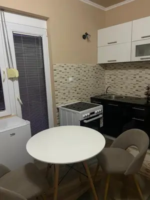 a small kitchen with a white table and chairs at Pause - cozy Podgorica apartment in Podgorica