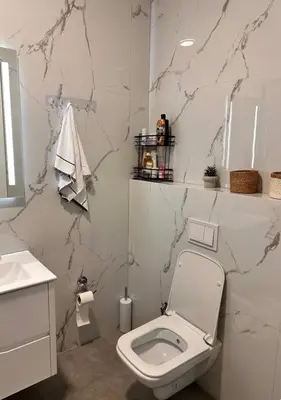 a white bathroom with a toilet and a sink at Azure Teuta apartment with balcony in Ulcinj