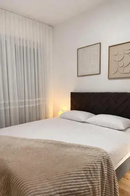 a bedroom with a large bed and a window at Azure Teuta apartment with balcony in Ulcinj