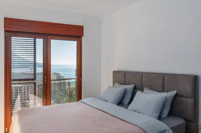 a bedroom with a bed with a large window at Panoramic Sea View 1BD Apartment in Becici