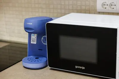 a blue food processor sitting next to a microwave at Panoramic Sea View 1BD Apartment in Becici