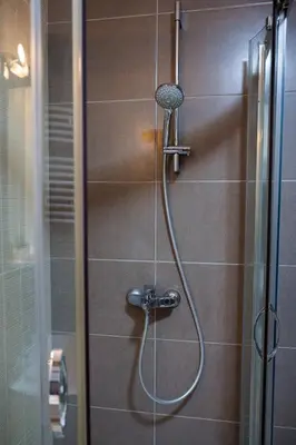 a shower with a hose in a bathroom at Panoramic Sea View 1BD Apartment in Becici