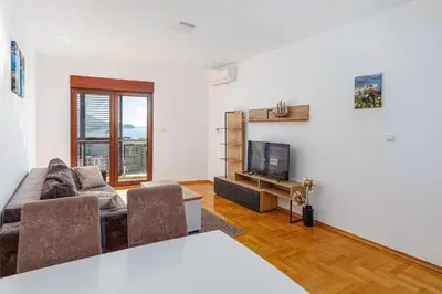 a living room with a couch and a television at Panoramic Sea View 1BD Apartment in Becici