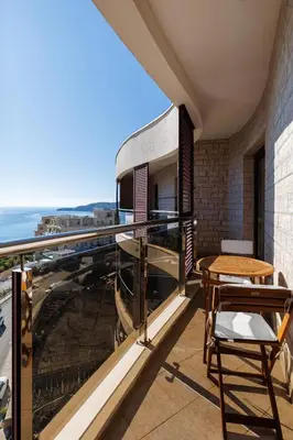 a balcony with a table and a view of the ocean at Panoramic Sea View 1BD Apartment in Becici