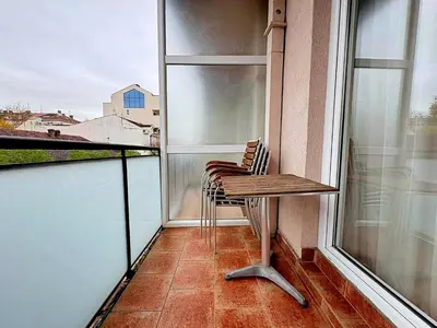 a chair sitting on a balcony with a window at MWA - City Soul Podgorica in Podgorica