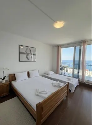 a bedroom with two beds and a view of the ocean at Apartmani S in Dobra Voda
