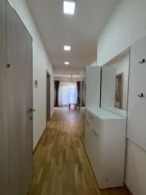 a hallway with white cabinets and a wooden floor at Bozovic Apartman 2 in Budva