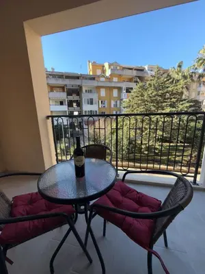a table and two chairs with a bottle of wine on a balcony at Bozovic Apartman 2 in Budva