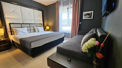 a bedroom with a bed and a couch at Azure Family Seaside Living Apartments Rafailovici in Becici