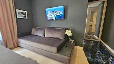 a couch in a living room with a painting on the wall at Azure Family Seaside Living Apartments Rafailovici in Becici