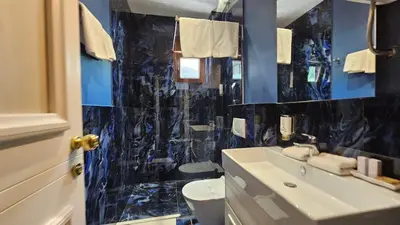 a blue bathroom with a sink and a toilet at Azure Family Seaside Living Apartments Rafailovici in Becici
