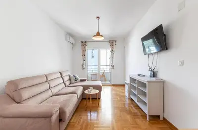 a living room with a couch and a tv at Evins Budva 1 Bedroom Apartment in Budva
