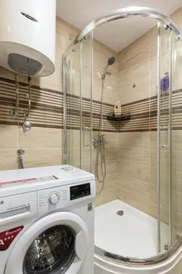 a washing machine in a bathroom with a shower at Evins Budva 1 Bedroom Apartment in Budva