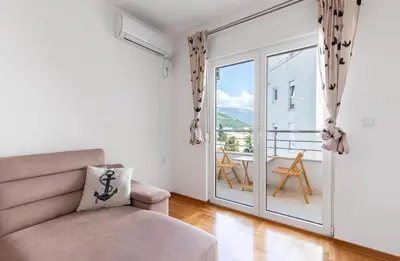 a living room with a couch and a sliding glass door at Evins Budva 1 Bedroom Apartment in Budva