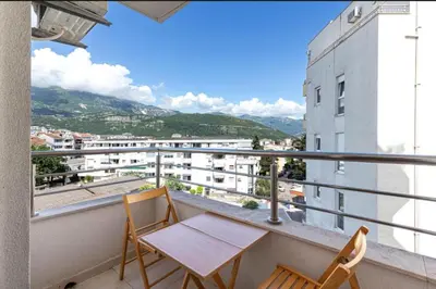 a balcony with two chairs and a table on a building at Evins Budva 1 Bedroom Apartment in Budva