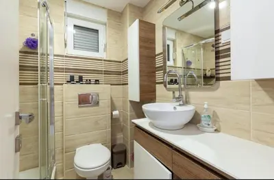 a bathroom with a sink and a toilet and a shower at Evins Budva 1 Bedroom Apartment in Budva