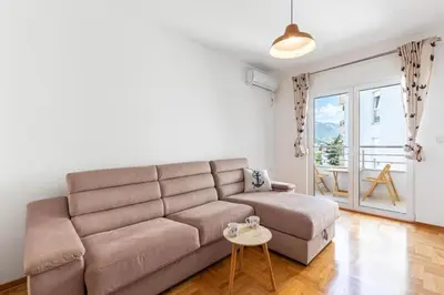 a living room with a couch and a table at Evins Budva 1 Bedroom Apartment in Budva