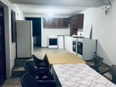 a kitchen with a table and chairs and a refrigerator at New ROZANA in Ulcinj