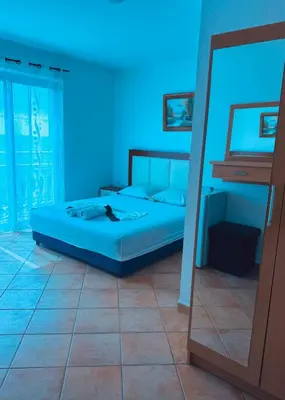 a bedroom with a bed with a blue light at New ROZANA in Ulcinj