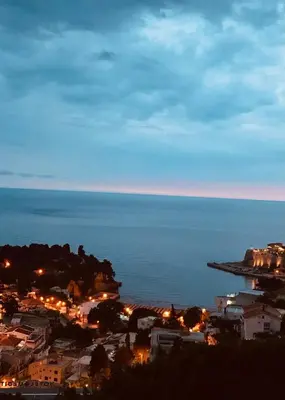 a view of a city with the ocean at night at New ROZANA in Ulcinj
