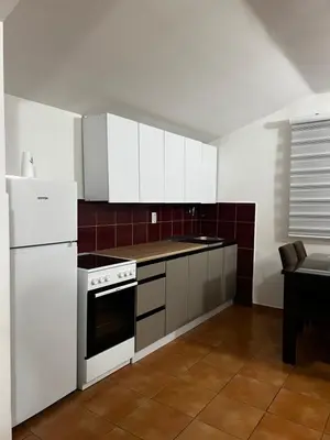 a kitchen with white appliances and a table in it at Kuca in Lajkovići