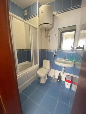 a blue bathroom with a toilet and a sink at Apartament Nadia DUBRAVA BAR in Dobra Voda