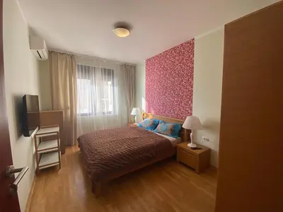 a bedroom with a bed and a pink wall at Apartament Nadia DUBRAVA BAR in Dobra Voda