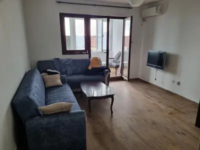a living room with a blue couch and a table at Buddub in Budva