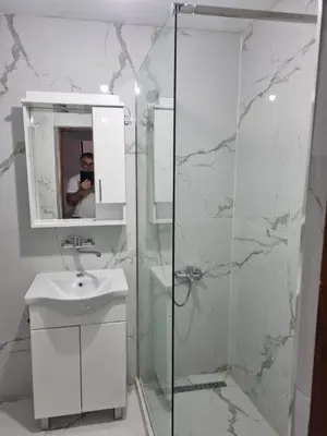 a bathroom with a shower and a sink and a mirror at Buddub in Budva