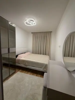 a small bedroom with a bed and a mirror at Aurora apartment in Cetinje