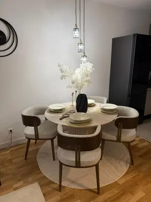 a dining room table with chairs and a vase of flowers at Aurora apartment in Cetinje