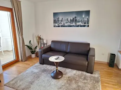 a living room with a couch and a table at Luxury Apartment-Aurora 33 Free Parking City Center in Podgorica