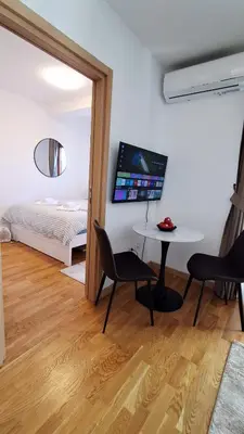 a room with a table and chairs and a bed at Luxury Apartment-Aurora 33 Free Parking City Center in Podgorica