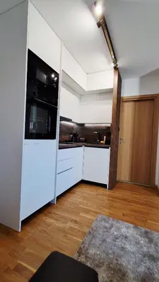a kitchen with white cabinets and a black appliance at Luxury Apartment-Aurora 33 Free Parking City Center in Podgorica
