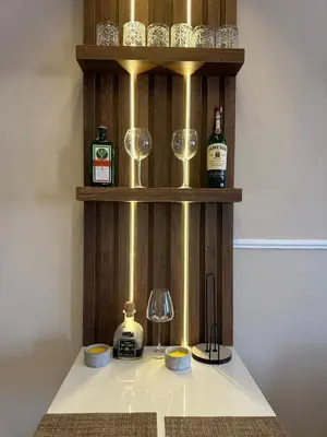 a shelf with wine glasses and bottles on a counter at Dobrota Luxury House with Kotor Gulf View in Dobrota