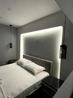 a bedroom with a bed with a light on the wall at Dobrota Luxury House with Kotor Gulf View in Dobrota