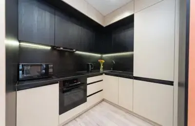 a kitchen with black and white cabinets and a microwave at Apartmani Drivasko in Sveti Stefan