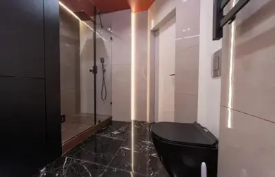 a bathroom with a black toilet and a shower at Apartmani Drivasko in Sveti Stefan