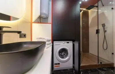 a bathroom with a sink and a washing machine at Apartmani Drivasko in Sveti Stefan