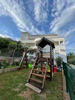 a wooden play set in front of a house at Apart Sara in Ulcinj