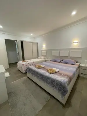 two beds in a large room with two bedsvisor at Apart Sara in Ulcinj