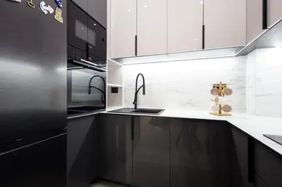 a kitchen with black and white cabinets and a sink at Seaview Residence in Dobra Voda
