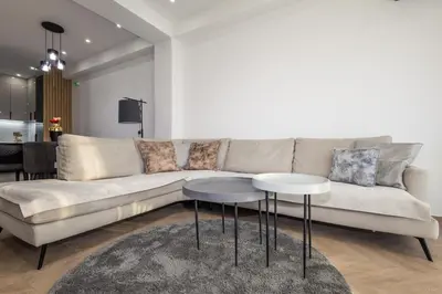a living room with a couch and two tables at Seaview Residence in Dobra Voda
