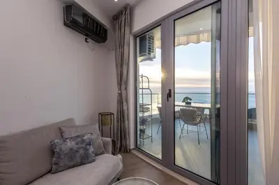 a living room with a couch and a view of the ocean at Seaview Residence in Dobra Voda