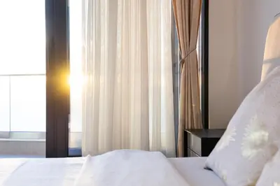 a bedroom with a white bed and a window at Seaview Residence in Dobra Voda